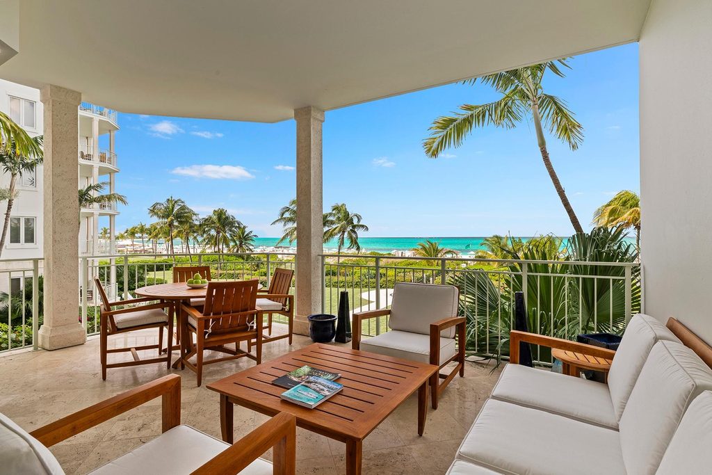 West Bay Club Unit 206 oceanfront balcony with dining and lounge seating, Grace Bay Beach, Turks and Caicos
